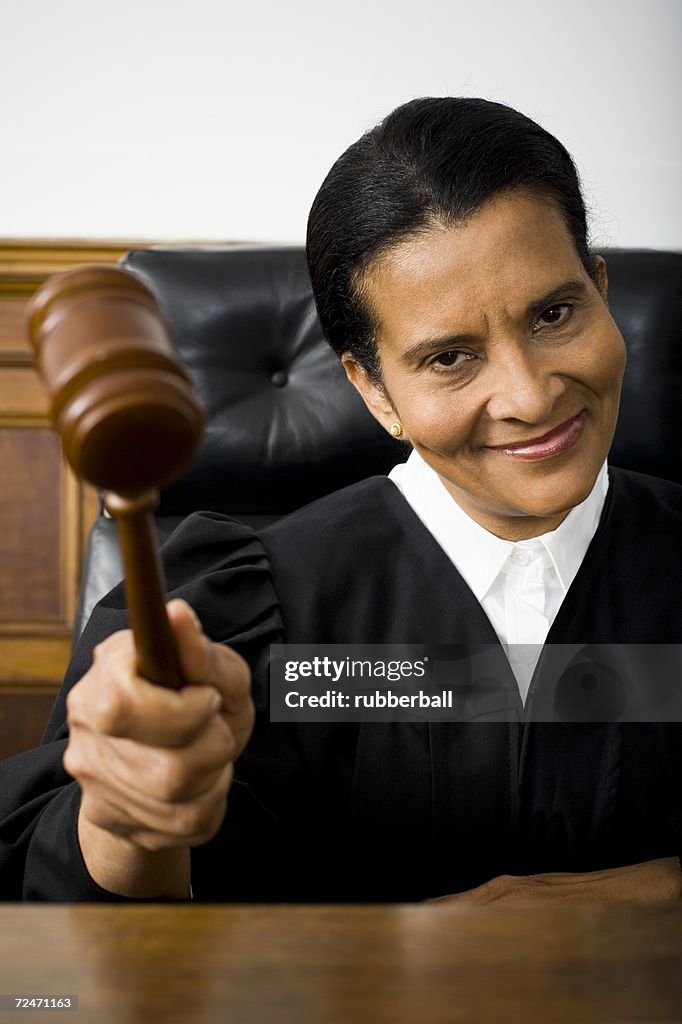 Portrait of a female judge holding a gavel and smiling