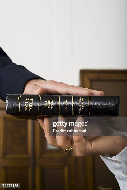 close-up of a witnesses hand swearing over the bible - witness stock pictures, royalty-free photos & images