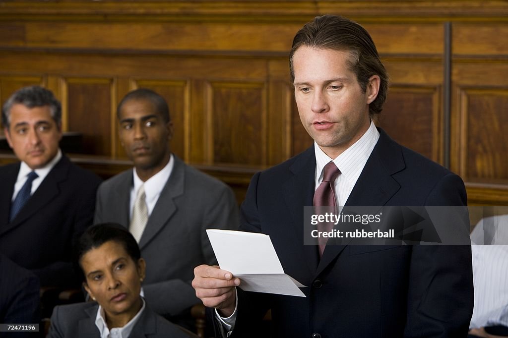 Juror standing in a jury box and reading the verdict