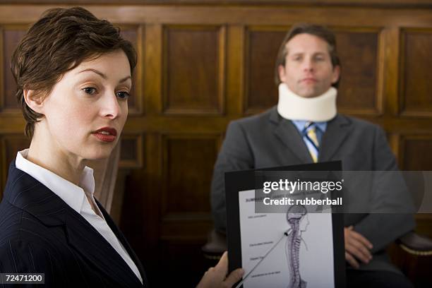 a female lawyer pointing at evidence in front of a victim in a courtroom - victim advocate stock pictures, royalty-free photos & images