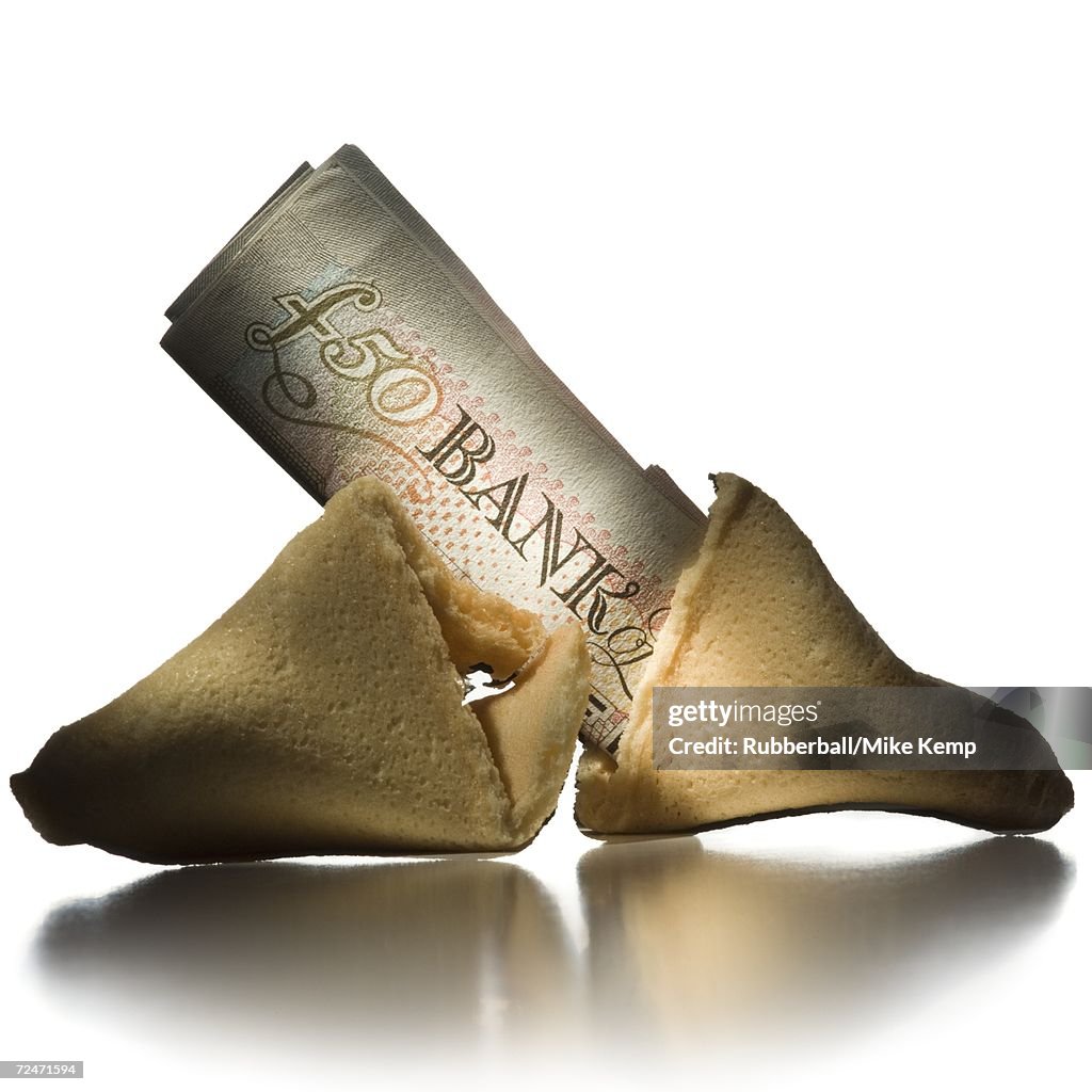 Close-up of a fifty pound banknote in a broken fortune cookie