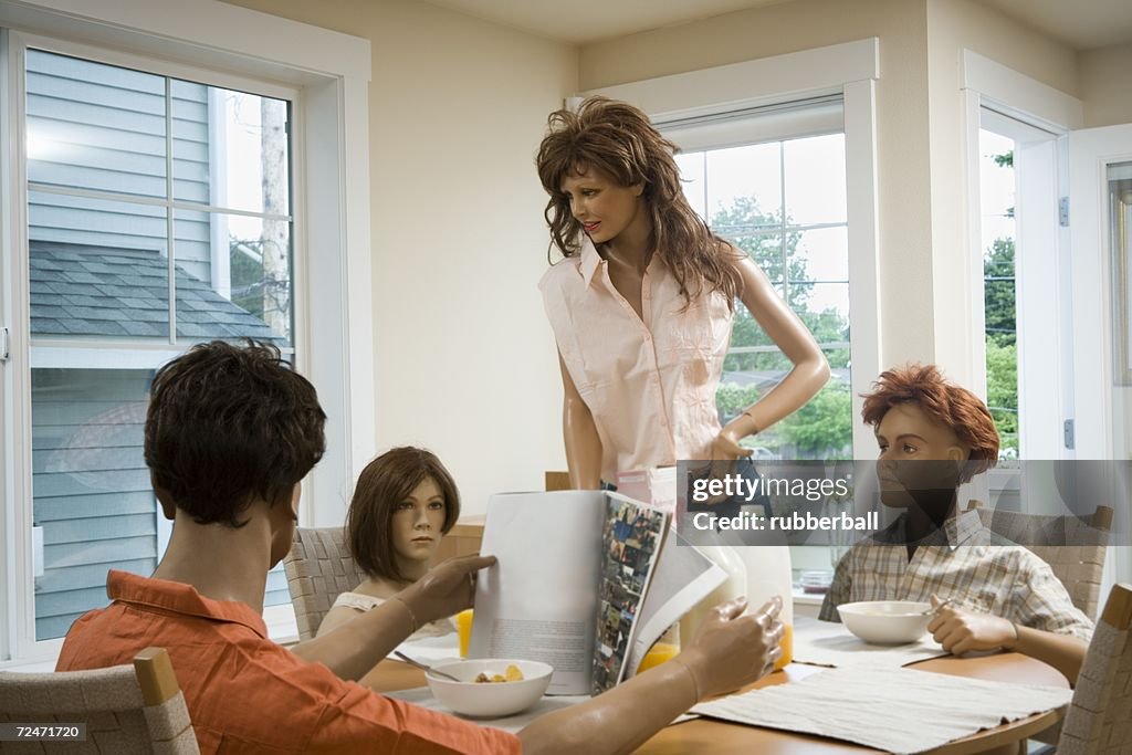 Four mannequins portraying a family at the dining table