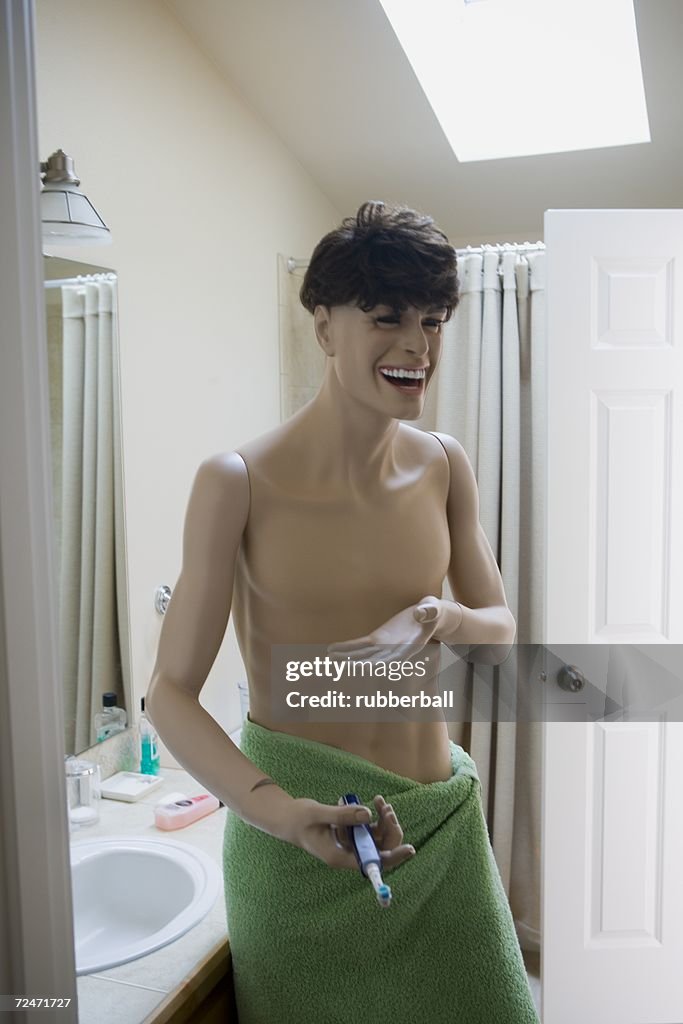 Close-up of a male mannequin holding a toothbrush in the bathroom