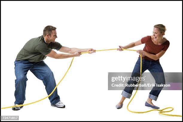 young couple playing tug-of-war - man pulling object fotografías e imágenes de stock