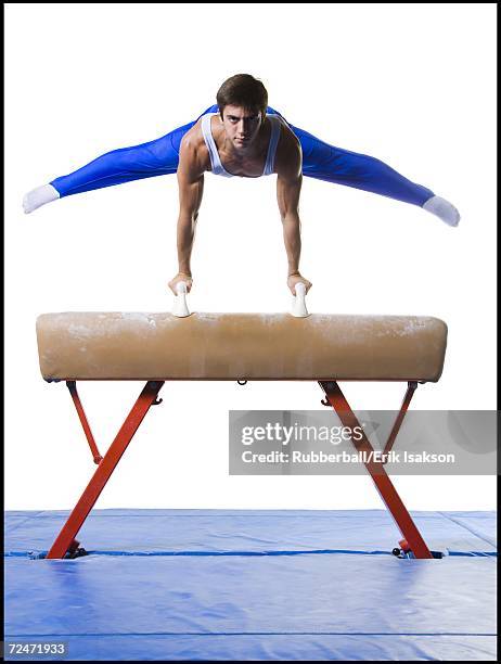 male gymnast performing on vaulting horse - cavallo a maniglie foto e immagini stock