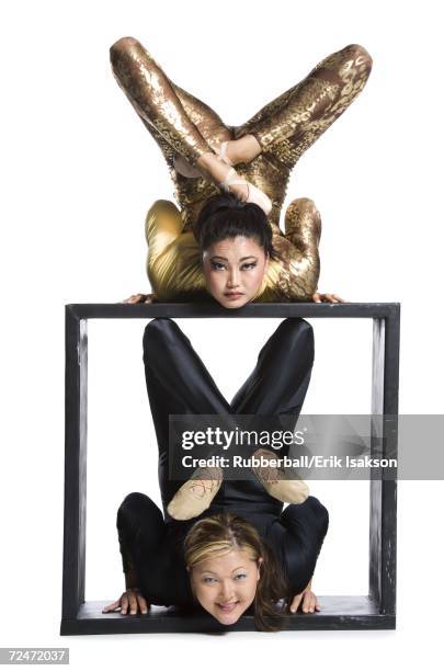 female contortionist duo with box prop - circus contortionist stock pictures, royalty-free photos & images