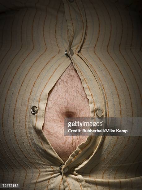 close-up of fat stomach bursting through shirt - barrigón fotografías e imágenes de stock