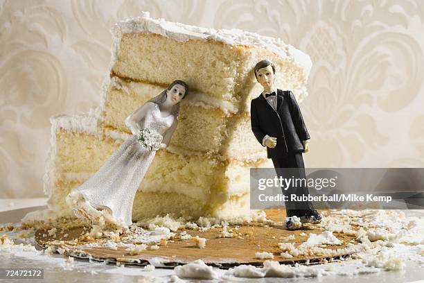 wedding cake visual metaphor with figurine cake toppers - wedding cake stock pictures, royalty-free photos & images