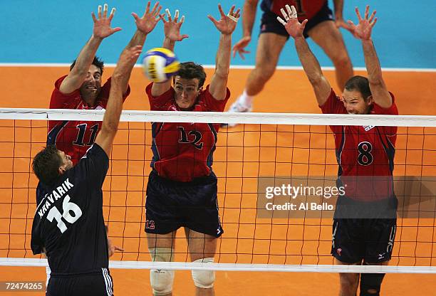 Thomas Hoff, Brook Billings, and William Paddy of the USA block the shot of Antrel Kravarik Greece in the men's indoor Volleyball quarterfinal match...