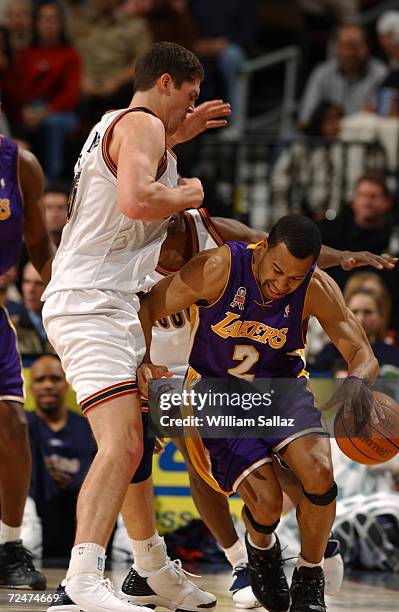Guard Derek Fisher of the Los Angeles Lakers dribbles the ball around center Chris Andersen of the Denver Nuggets during the NBA game at Pepsi Center...