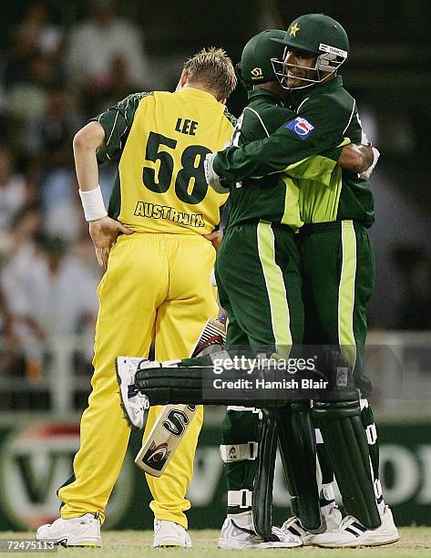 Abdul Razzaq and Naved-ul-Hasan of Pakistan celebrate the winning runs as Brett Lee of Australia looks on during game eight of the VB Series One Day...