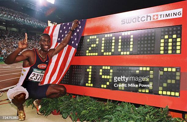 Michael Johnson of the USA poses next to his new world record time of 19.32 seconds in the men's 200 meters during Centennial Olympic Games at...