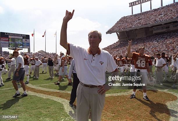 Head coach John Mackovic of the Texas Longhorns raises his hand in the air as he siganls the "hook'em horns" while playing the Texas anthem during...