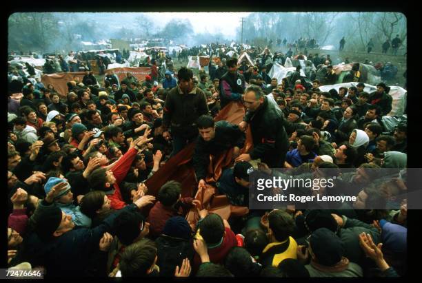 Relief workers hand supplies to refugees April 1, 1999 in Macedonia. Thousands of Kosovar Albanians fled the violence in Serbia and arrived at Blace,...