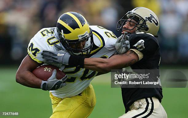 Michael Hart of the Michigan University Wolverines gets tackled by Brian Hickman of the Purdue University Boilermakers during the first half of the...