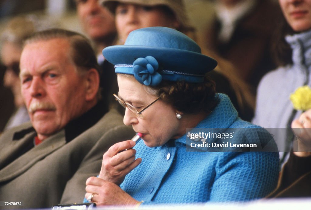 Queen Elizabeth II putting on lipstick