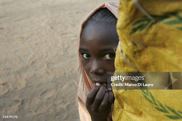 Sudanese refugee girl peeps out of her shelter on November 8, 2006 in the Goz Amer Refugee Camp, Chad. Since 2004 refugees have fled from Darfur into...