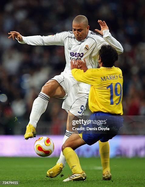 Ronaldo of Real Madrid is challenged by Mario of Ecija in the Kings Cup fourth round second leg match at the Santiago Bernabeu stadium on November 9,...
