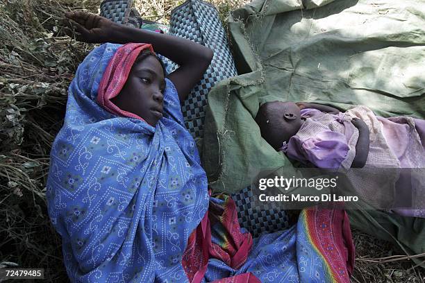 Chadian village girl and her baby find shelter under trees after an attack on their village forced them to flee on November 9, 2006 in a camp for...