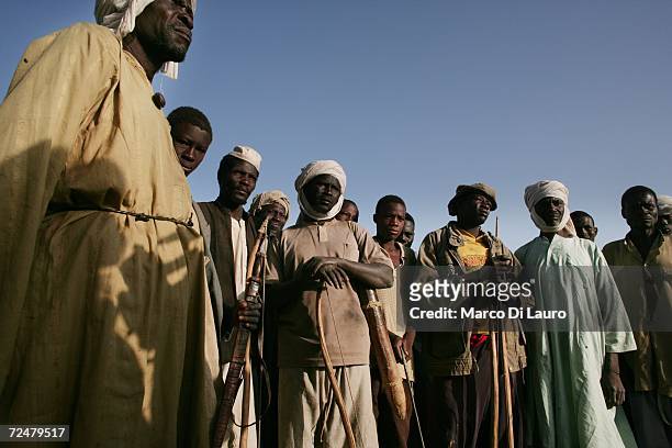 Chadian village elders carry bow and arrows as they discuss how to defend their families after an attack on their village forced them to flee on...