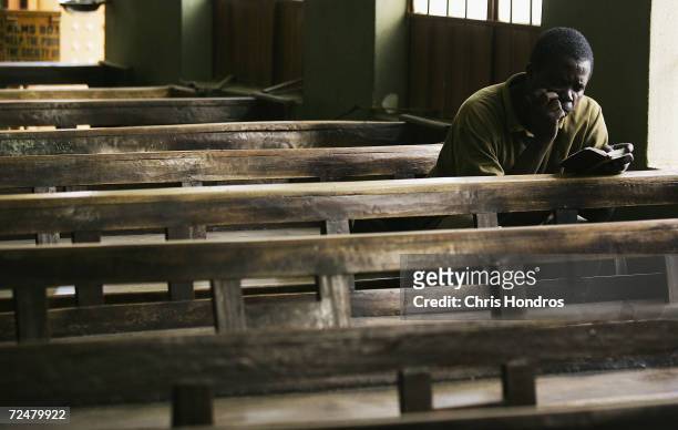 Nigerian worshipper reads through his Bible after other parish members have left April 12, 2005 in Kano, Nigeria. Kano is part of Nigeria's primarily...