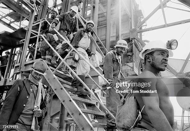 Miners emerge from a cage after a shift at the Kloof Gold Mine near Carltonville, South Africa. The mine is owned by one of the worlds biggest...