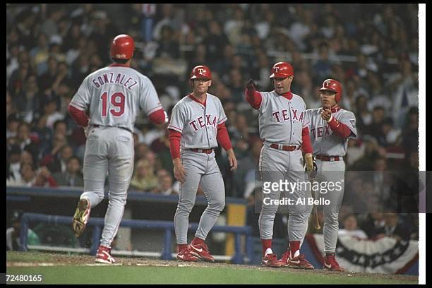 Texas Rangers players congratulate Juan Gonzalez after he scores during a game against the New York Yankees at Yankee Stadium in New Yok City, New...