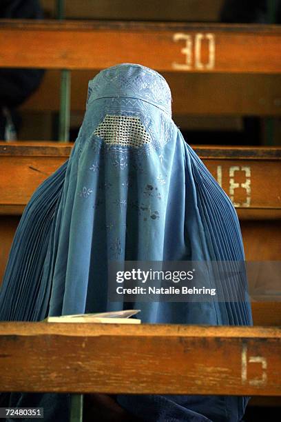 An Afghan woman, wearing a burqa, sits in a lecture hall February 20, 2002 as she waits to take a university entrance exam at Kabuls Polytechnic...