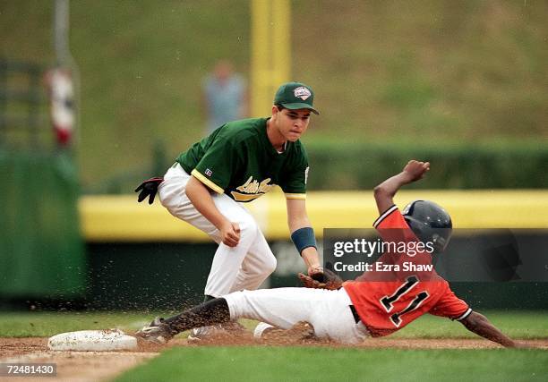 Andre Lewis of Team Europe slides into a base as Jose Casanova of Team Latin America tags him during the Little League World Series Game in...