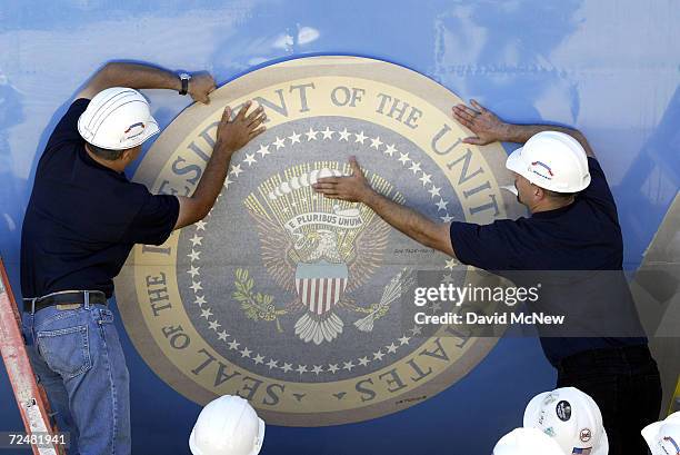 Workers make last-minute adjustments to the presidential seal on Air Force One before the "moving-in ceremony" of the Ronald Reagan presidential-era...