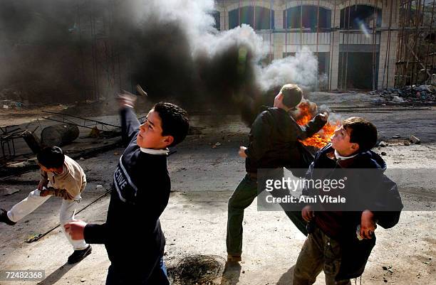 Palestinian children hurl stones January 28, 2003 in the West Bank city of Nablus. Israelis are voting in general elections and have blocked all...