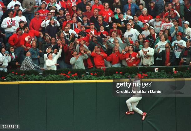 Outfielder Brian Jordan of the St. Louis Cardinals scales the outfield wall for a Ken Caminiti of the San Diego Padres home run in game 2 of the...