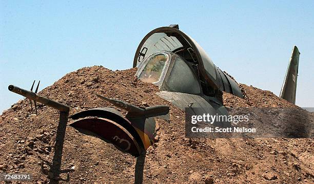 An Iraqi Air Force MiG fighter jet is buried in the sand near the Tamous air base August 2, 2003 at Habaniya, Iraq, about 120 kilometers northeast of...