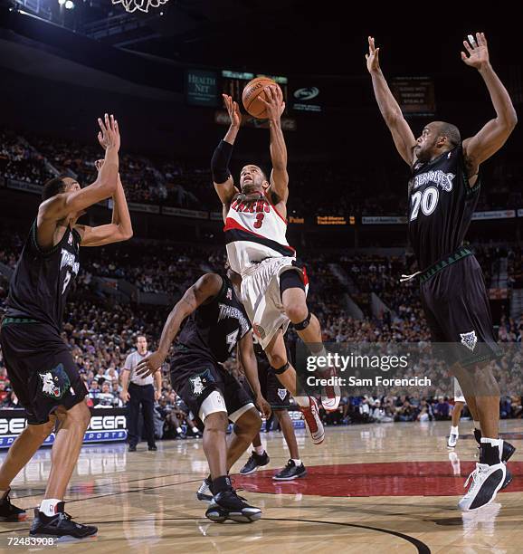 Point guard Damon Stoudamire of the Portland Trail Blazers shoots over center Loren Woods of the Minnesota Timberwolves during the NBA game at the...