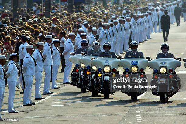 Policemen on motorcycles drive ahead of the horse drawn procession as it makes its way down Constitution Avenue enroute to the Capitol June 9, 2004...