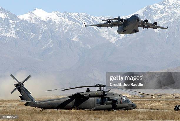 Airforce C-17 takes off the runway past an Army Blackhawk helicopter March 12, 2002 at the Bagram airbase near Kabul, Afghanistan. The equipment are...