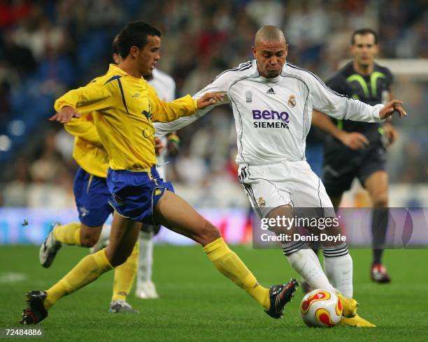 Ronaldo of Real Madrid is challenged by Requena of Ecija in the Kings Cup fourth round second leg match at the Santiago Bernabeu stadium on November...