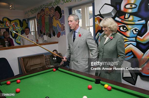Prince Charles, Prince of Wales, watched by Camilla, Duchess of Cornwall, plays pool with teenagers on November 9, 2006 as they visit the Jubilee...