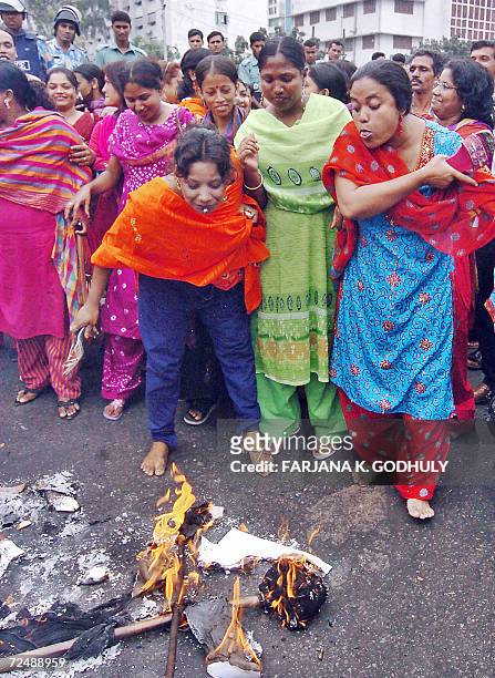 Bangladeshi activists from the youth wing of Awami League spit after they set fire to an effigy of chief election commissioner M. A. Aziz during a...