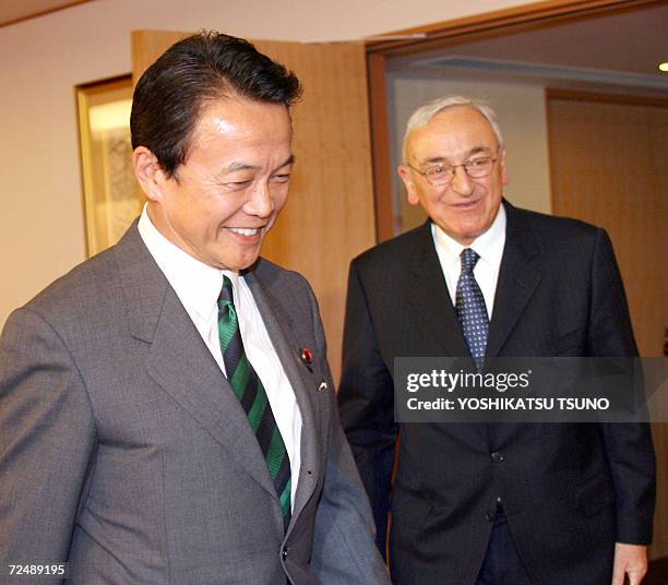 Visiting International Energy Agency Executive Director Claude Mandil is greeted by Japanese Foreign Minister Taro Aso for their talks at Aso's...