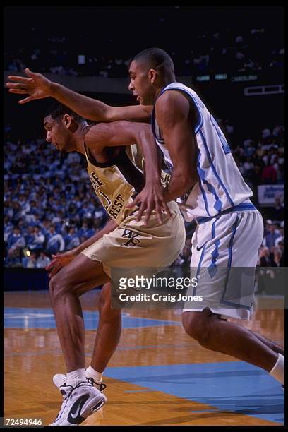 Center Tim Duncan of the Wake Forest Demon Deacons blocks forward Ademola Okulaja of the University of North Carolina Tar Heels at the Dean Dome in...