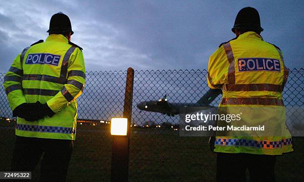 Police watch as four Britons arrive at RAF Northolt from Guatanamo Bay, January 25, 2005 in west London, England. Detainees Moazzam Begg, Martin...