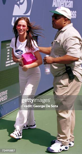 Actress Jennifer Love Hewitt escorted by a security guard attends August 26 the Arthur Ashe Kid's Day Family and Music Festival August 26, 2000 at...