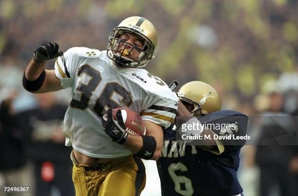 Fullback Craig Stucker of the Army Cadets in action against cornerback Bas Williams of the Navy Midshipmen during the game at Veterans Stadium in...