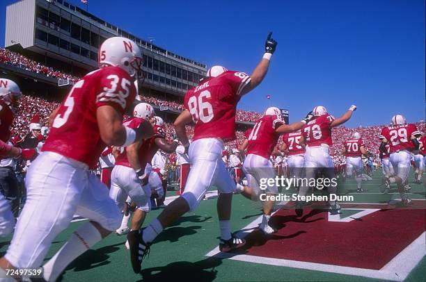 Team members from Nebraska Cornhuskers sprint onto the field during pre game intorductions as the team enters from the lockerroom just before the...