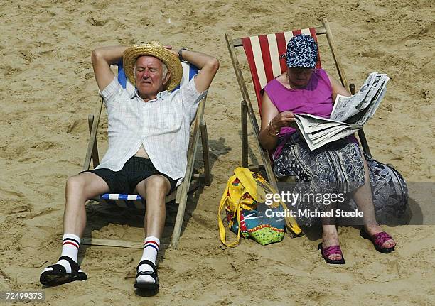 An elderly couple soak up the sun on Blackpool beach August 6, 2003 in Blackpool, England. The temperature in the UK peaked at 35.9 degrees Celsius...