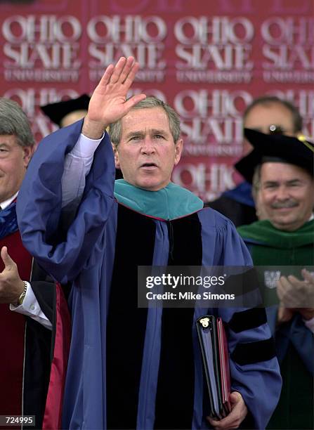 President George W. Bush waves after receiving an honorary doctorate at the Ohio State University Spring commencement June 14, 2002 in Columbus,...