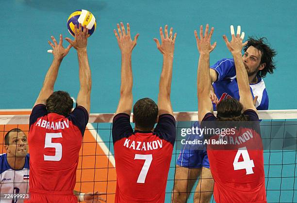 Goran Vujevic of Serbia and Montenegro attempts to spike the ball against Pavel Abramov, Alexey Kazakov and Sergey Baranov of Russia n the men's...