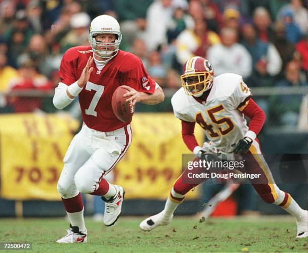 Boomer Esiason of the Arizona Cardinals runs from Washington Redskins defenders during the Cardinals 37-34 overtime win at RFK Stadium in Washington...