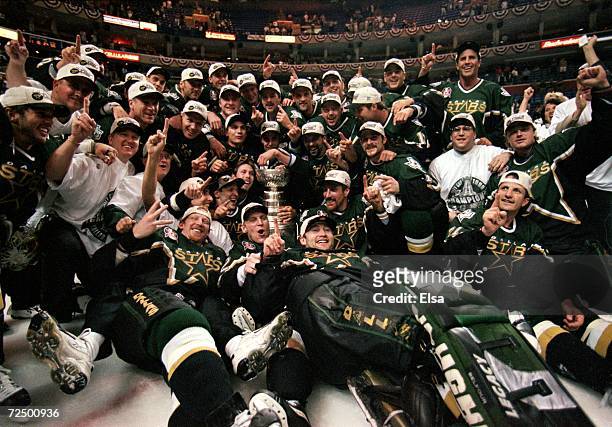 The Dallas Stars pose for a team photo with the Stanely Cup trophy as they celebrate the win over the Buffalo Sabres at the Marine Midland Arena in...